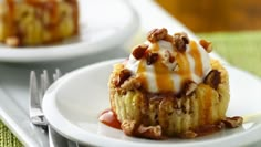 two small desserts on white plates with forks