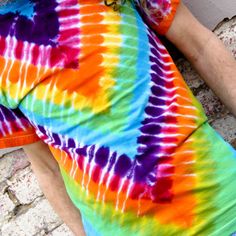 a man laying on the ground wearing a tie dye shirt