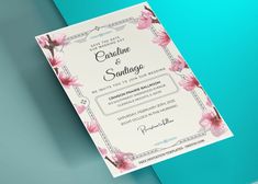 a wedding card with pink flowers on the front and back, sitting on top of a blue background