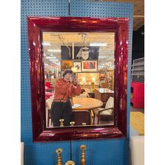 a man taking a selfie in front of a mirror at a furniture showroom