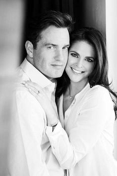 a man and woman are posing for a black and white photo with their arms around each other