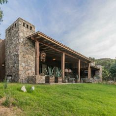 a stone building sitting on top of a lush green field