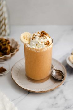 a dessert with whipped cream, banana slices and granola in it on a plate