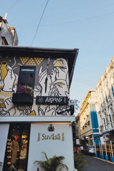 the side of a building with an artistic mural on it's wall and windows