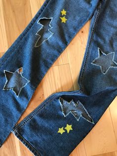 a pair of blue jeans with yellow stars on the bottom and one in the back