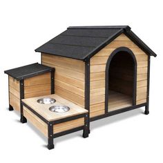 a wooden dog house with two bowls on the outside and one in the inside side