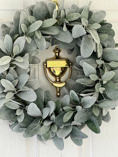 a wreath is hanging on the door with a golden lightbulb attached to it