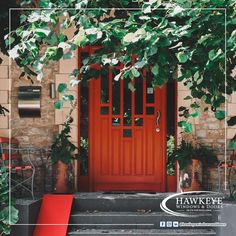 a red door surrounded by greenery in front of a brick building with the words hawkey on it