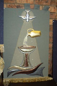 a painting with gold and silver accents on a brick wall next to a wooden table