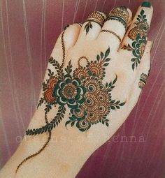 a woman's hand with henna tattoos on it