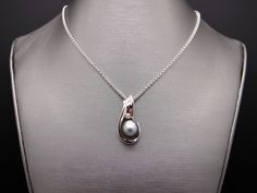 Estate 14kt White Gold Genuine Black Tahitian South Sea 11mm Pearl & .05ct Diamond Pendant. Set into this wonderful, 1 inch by 1/2 inch, pendant is 1 Fine Quality Black Tahitian South Sea Pearl which measures 11mm. The Pearl is black/gray with strong luster and nacre thickness and very few blemishes. Also set is 1 fine quality Round Brilliant Cut Diamonds H color, SI-1 clarity weighing 0.05cts total approx. This beautiful Estate 14kt White Gold 11mm Black South Sea Pearl & Diamond Pendan Tahitian Pearl Round Pendant Necklace For Anniversary, Fine Jewelry Tahitian Pearl Necklace For Anniversary, Tahitian Pearl Fine Jewelry Necklace For Anniversary, Tahitian Pearl Necklace For Anniversary, Silver Tahitian Pearl Round Pendant Jewelry, Silver Tahitian Pearl Pendant, Silver Tahitian Pearl Pendant Jewelry, Silver Tahitian Pearl Necklace Fine Jewelry, Silver Tahitian Pearl Necklace