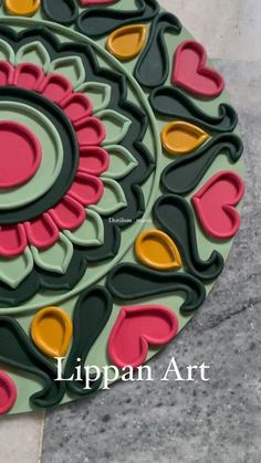 a circular tray with hearts on it sitting on the ground next to a tile floor