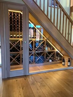 a wine cellar under the stairs in a house