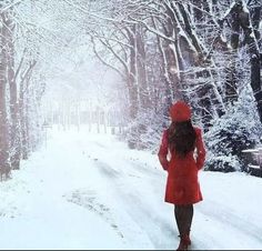 a woman walking down a snow covered road