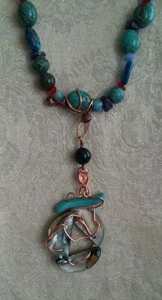 This is a 4 strand glass,stone, and metal beaded statement necklace. It is comprised of glass and stone (carnelian,agate,coral, dyed howlite, turquoise, jasper, lapis, shattuckite, abalone) beads in shades of red and blue, copper wire, silvertone jump rings, and a silvertone lobster claw clasp. The necklace is strung on nylon coated steel wire.Shortest strand = 19" Longest strand = 30" Focal = 4.25" Unique Multicolor Copper Necklace, Multicolor Copper Necklace, Unique Wire Wrapped Beaded Necklaces With Round Beads, Unique Wire Wrapped Round Beaded Necklaces, Unique Adjustable Chrysocolla Necklace, Handmade Turquoise Agate Necklace For Healing, Bohemian Chrysocolla Beaded Necklaces For Jewelry Making, Bohemian Jasper Wire Wrapped Necklaces, Wire Wrapped Necklaces With Round Beads