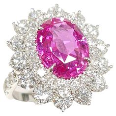 Prepare to be captivated by the enchanting beauty of this exquisite GRS Certified 5.41 Carat Sapphire, boasting a rare Vivid Pink color in an elegant oval shape. This remarkable gemstone takes center stage in a cluster-style ring, encircled by natural diamonds, all set in 18K white gold with a double halo design. Adding to its allure, the ring features 14 pieces of round brilliant diamonds, weighing an impressive 2.64 carats in total. Originating from Madagascar, the high-quality Pink Sapphire radiates a truly mesmerizing hue. GRS Certification guarantees the authenticity and exceptional quality of this gemstone, ensuring that its Vivid Pink color is incredibly rare and highly sought after. The oval shape of the sapphire enhances its elegance and allows for optimal brilliance and play of l Imvu Outfits, Imvu Outfits Ideas Cute, Halo Design, Halo Setting, Double Halo, Wedding Rings Vintage, Cute Rings, Center Stage, Color Rosa