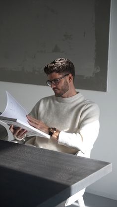 a man sitting at a table reading a paper