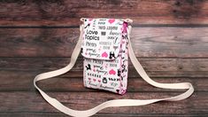 a white bag with pink hearts on it sitting on top of a wooden floor next to a