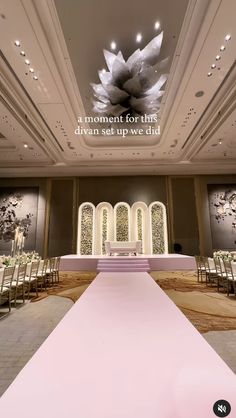 a large room with rows of chairs and a pink carpet on the floor that is decorated with white flowers