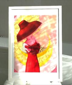 a painting with a red hat on top of it in front of a white frame