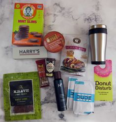 the contents of a snack box laid out on a marble counter top, including donuts, chips, and coffee