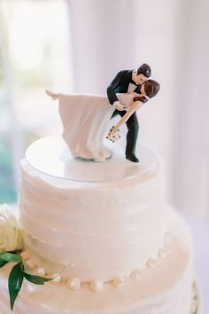 a wedding cake with a bride and groom figurine on top