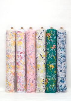 six different colors of fabric with flowers and butterflies on them, all lined up in rows