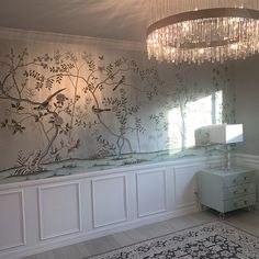 a chandelier hanging from the ceiling in a room with white walls and flooring