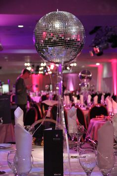 a disco ball on top of a table with wine glasses