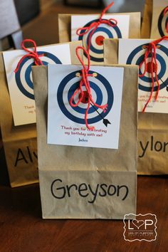 three brown paper bags with red twine tied to them, each bag has an arrow on it