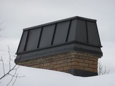 a chimney on top of a brick building in the snow