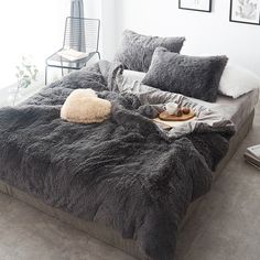 the bed is made up with grey fur and pillows