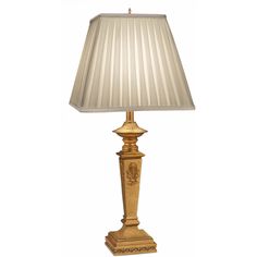 a gold lamp with a white shade on it's base and a beige lampshade