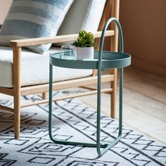 a small potted plant sitting on top of a glass table next to a chair