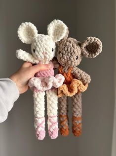 a person holding three crocheted animals in their hands