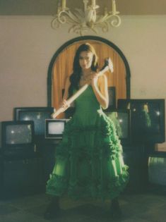 a woman in a green dress holding a bat