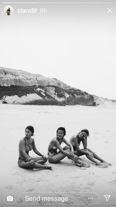 three women sitting on the beach in bathing suits