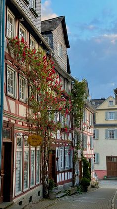 an old european street with flowers growing on the buildings