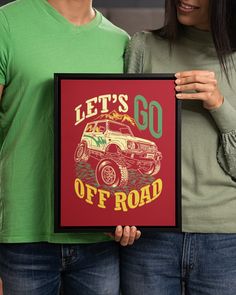 two people standing next to each other holding up a yellow poster that says let's go off road