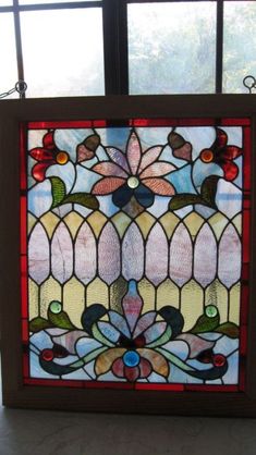 a stained glass window with flowers and leaves