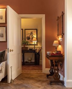 an open door leading to a living room with a couch and lamp on the side