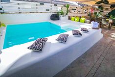 an outdoor swimming pool with pillows on the edge