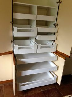 an empty pantry with white drawers and no doors