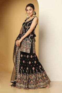 Black sleeveless padded short kurta in georgette base with all over mughal bloom art multi color thread, zari, mirror embroideries, sequin highlights and paan neckline. Paired with a floral motif embroidered sharara and mirror border embellished net dupatta. - Aza Fashions Sleeveless Anarkali With Mirror Work, Bollywood Style Sleeveless Chanderi Palazzo Set, Sleeveless Chanderi Bollywood Palazzo Set, Sleeveless Resham Embroidered Choli For Eid, Sleeveless Resham Embroidery Choli For Eid, Designer Sleeveless Sharara With Dupatta, Bollywood Sleeveless Palazzo Set For Navratri, Bollywood Style Sleeveless Cutdana Sets, Traditional Sleeveless Palazzo Set With Dupatta