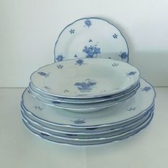 a stack of blue and white plates sitting next to each other on top of a table