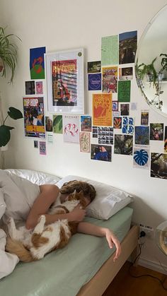 a woman laying in bed with her dog