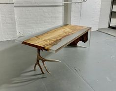 a wooden table with antlers on it in front of a white brick wall and floor