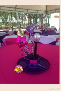 the table is set up with pink and purple decorations