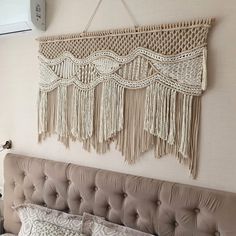 a bed with a headboard made out of macrame and pillows on top of it