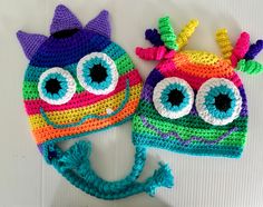 two crocheted hats with googly eyes on them